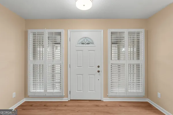 an empty room with wooden floor and windows