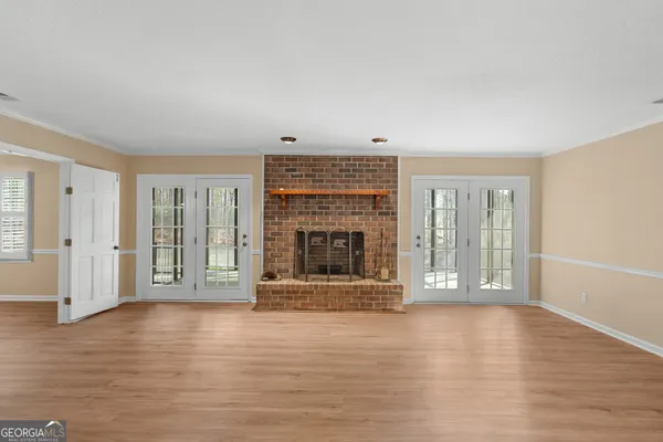 an empty room with wooden floor and fireplace