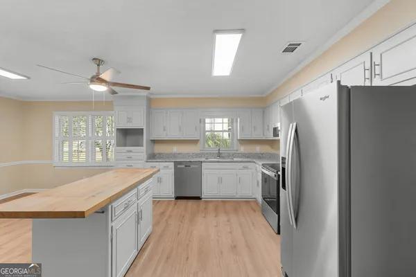 a kitchen with a refrigerator a sink dishwasher with a dining table and chairs