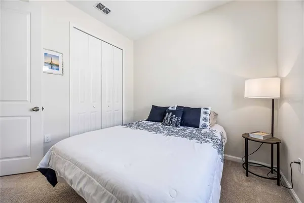 a bedroom with a bed a lamp and a window