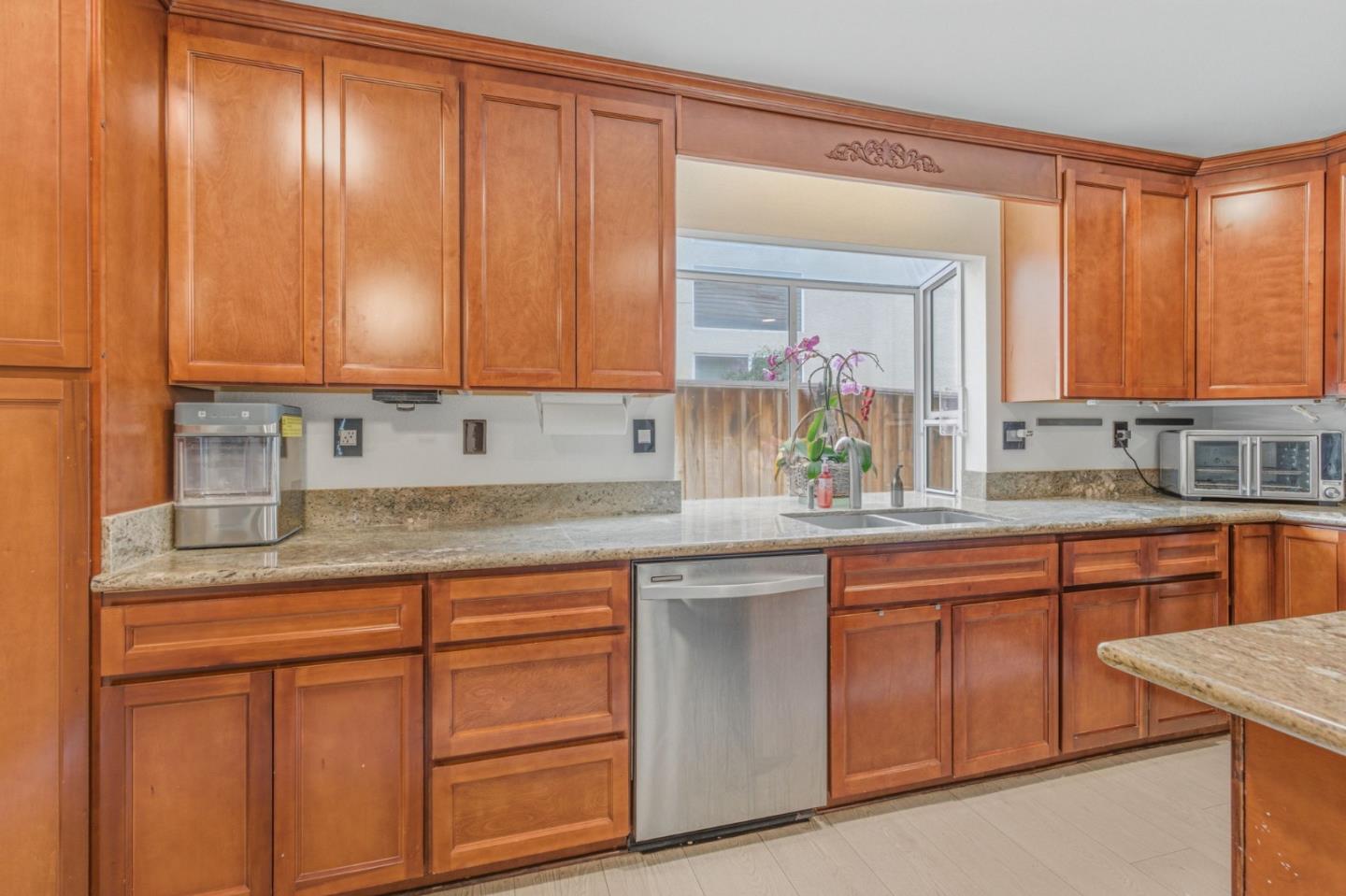 2678 Ramsdell Place San Jose, CA 95148 - Photo 22 of 41 a kitchen with kitchen island granite countertop wooden cabinets a sink and dishwasher
