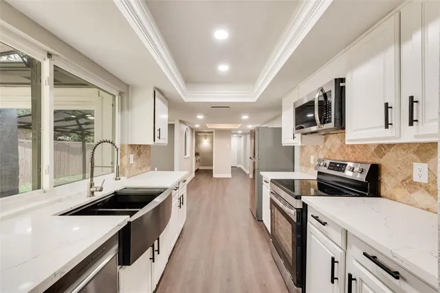 a kitchen with stainless steel appliances a sink stove and cabinets