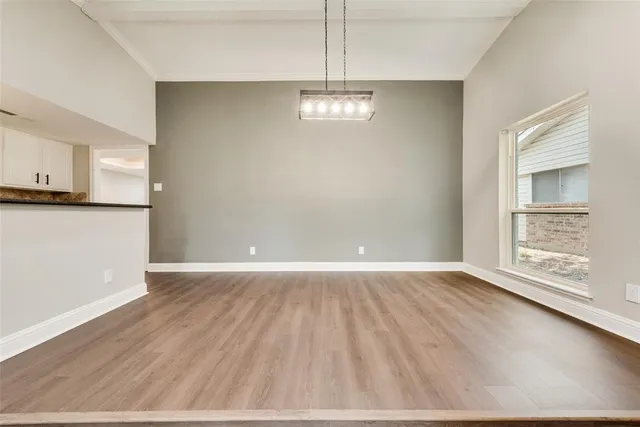 wooden floor in an empty room with a kitchen