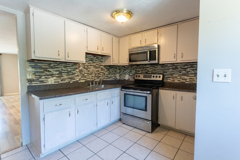 11 Tideview Path, Unit 17 Plymouth, MA 02360 - Photo 2 of 20 a kitchen with stainless steel appliances granite countertop a stove a sink and a refrigerator