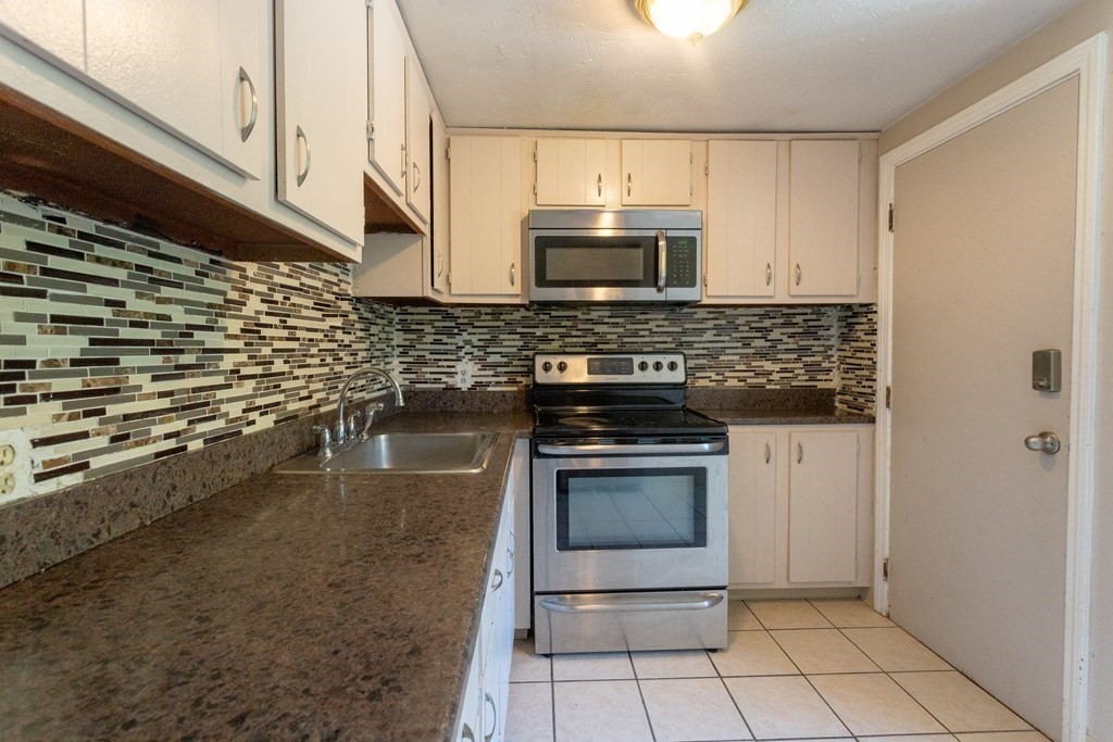11 Tideview Path, Unit 17 Plymouth, MA 02360 - Photo 3 of 20 a kitchen with stainless steel appliances granite countertop a stove a sink and a microwave