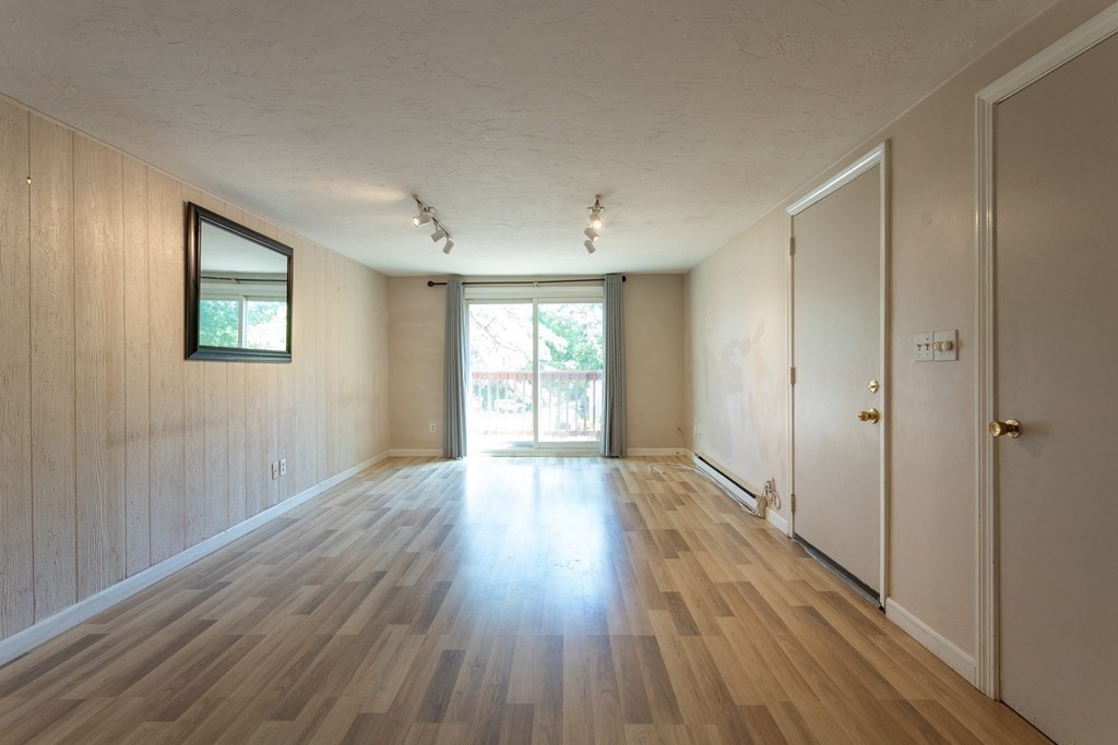11 Tideview Path, Unit 17 Plymouth, MA 02360 - Photo 6 of 20 a view of an empty room with wooden floor and a window