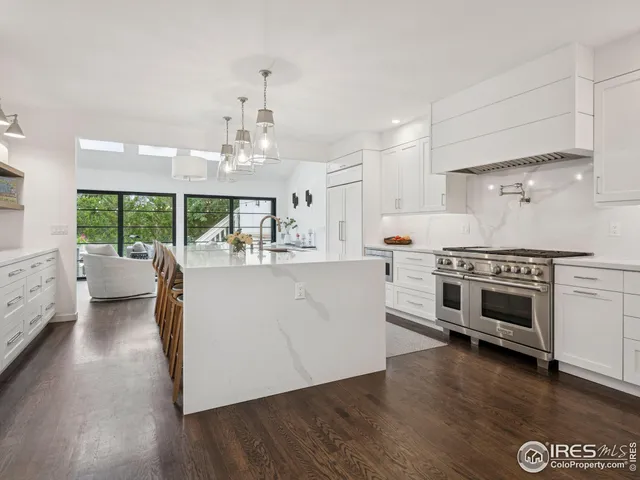 a kitchen with stainless steel appliances a stove top oven a sink a counter space and wooden floor