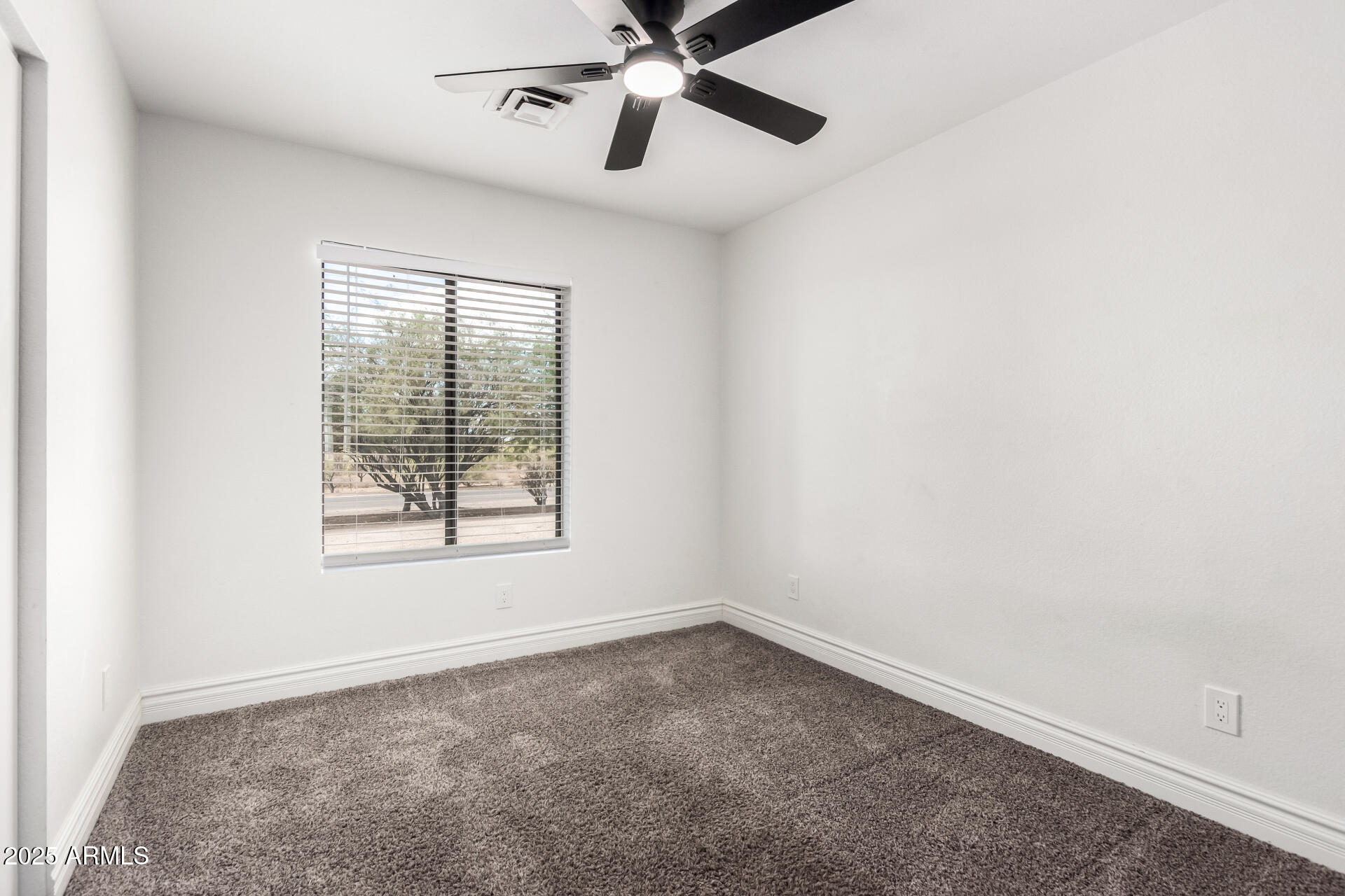 1737 South Mountain View Road Apache Junction, AZ 85119 - Photo 14 of 25 an empty room with a window and a fan