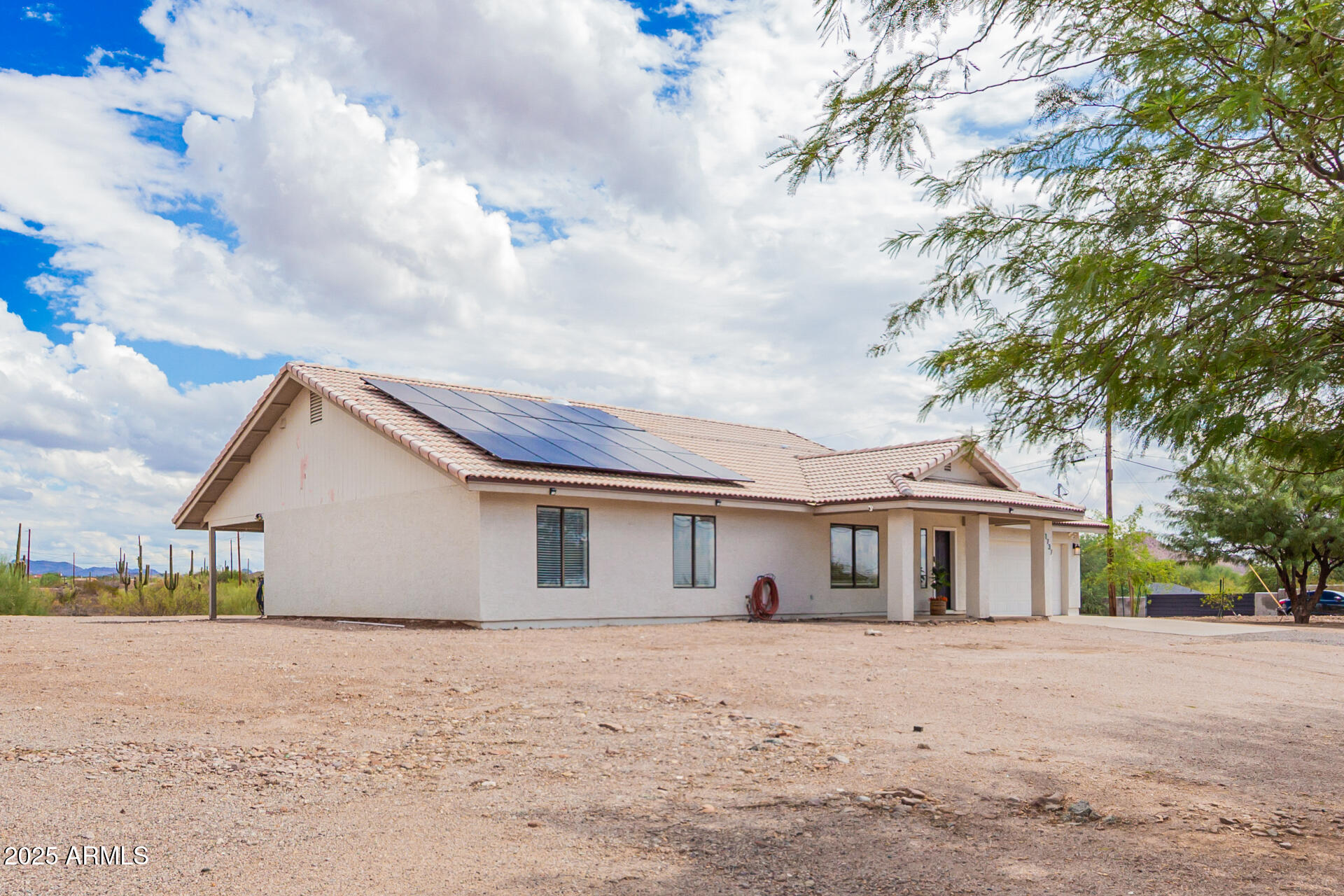 1737 South Mountain View Road Apache Junction, AZ 85119 - Photo 21 of 25 a front view of a house with a yard and garage
