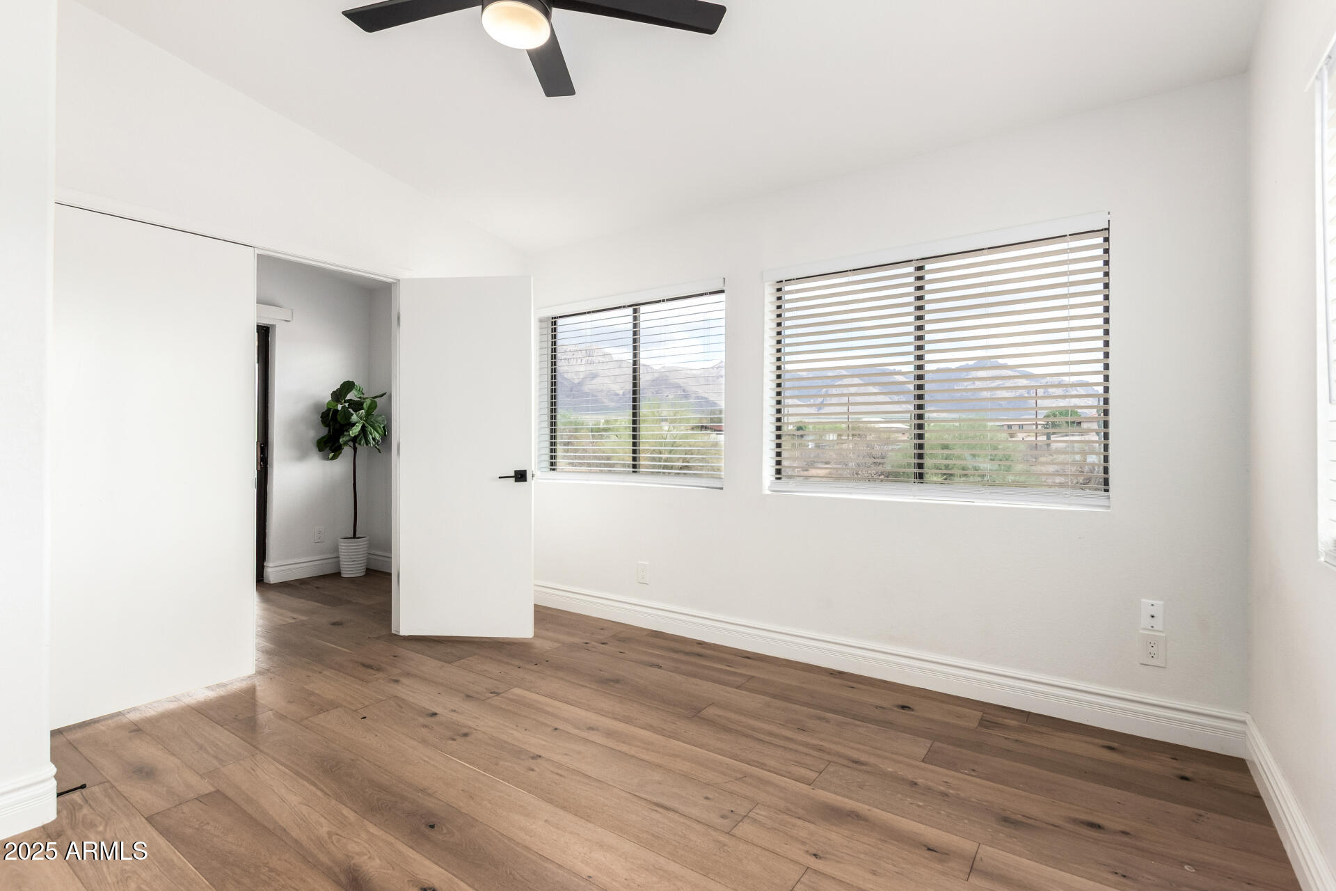 1737 South Mountain View Road Apache Junction, AZ 85119 - Photo 8 of 25 an empty room with wooden floor and windows