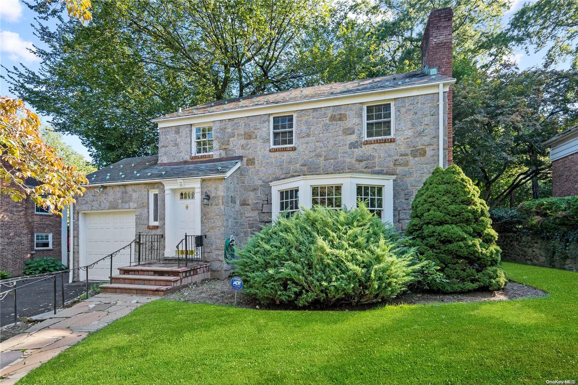 a front view of a house with a garden and yard