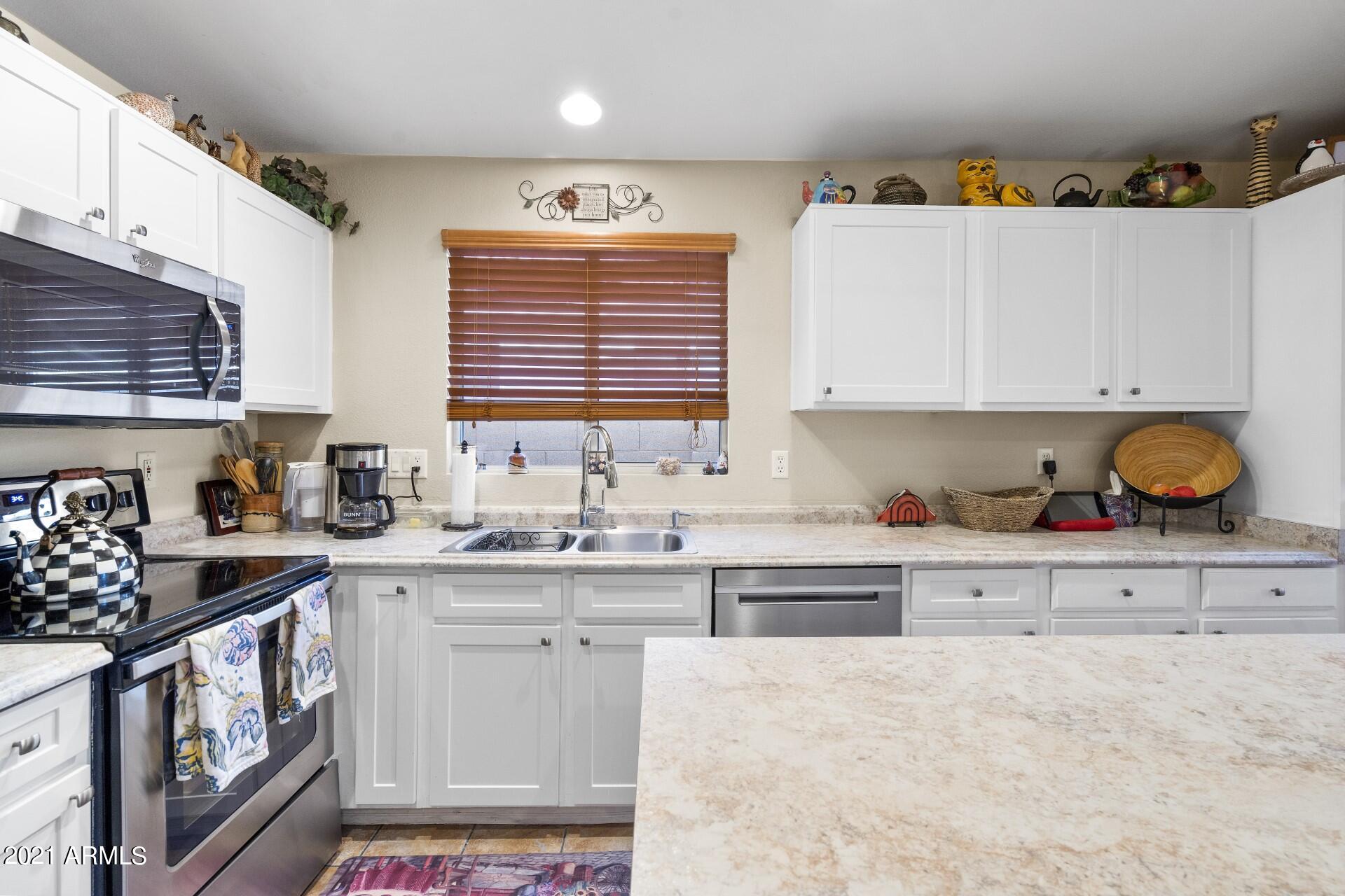 4161 West Bloomfield Road Phoenix, AZ 85029 - Photo 12 of 36 a kitchen with stainless steel appliances a stove a sink and cabinets
