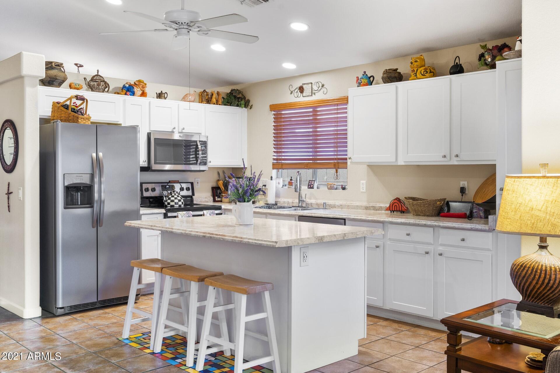 4161 West Bloomfield Road Phoenix, AZ 85029 - Photo 15 of 36 a kitchen with stainless steel appliances a sink a stove a refrigerator and cabinets