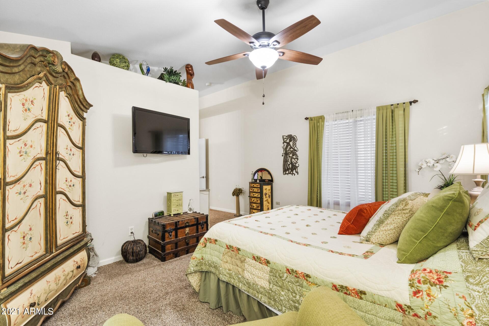 4161 West Bloomfield Road Phoenix, AZ 85029 - Photo 17 of 36 a bedroom with a bed a flat screen tv and a chandelier