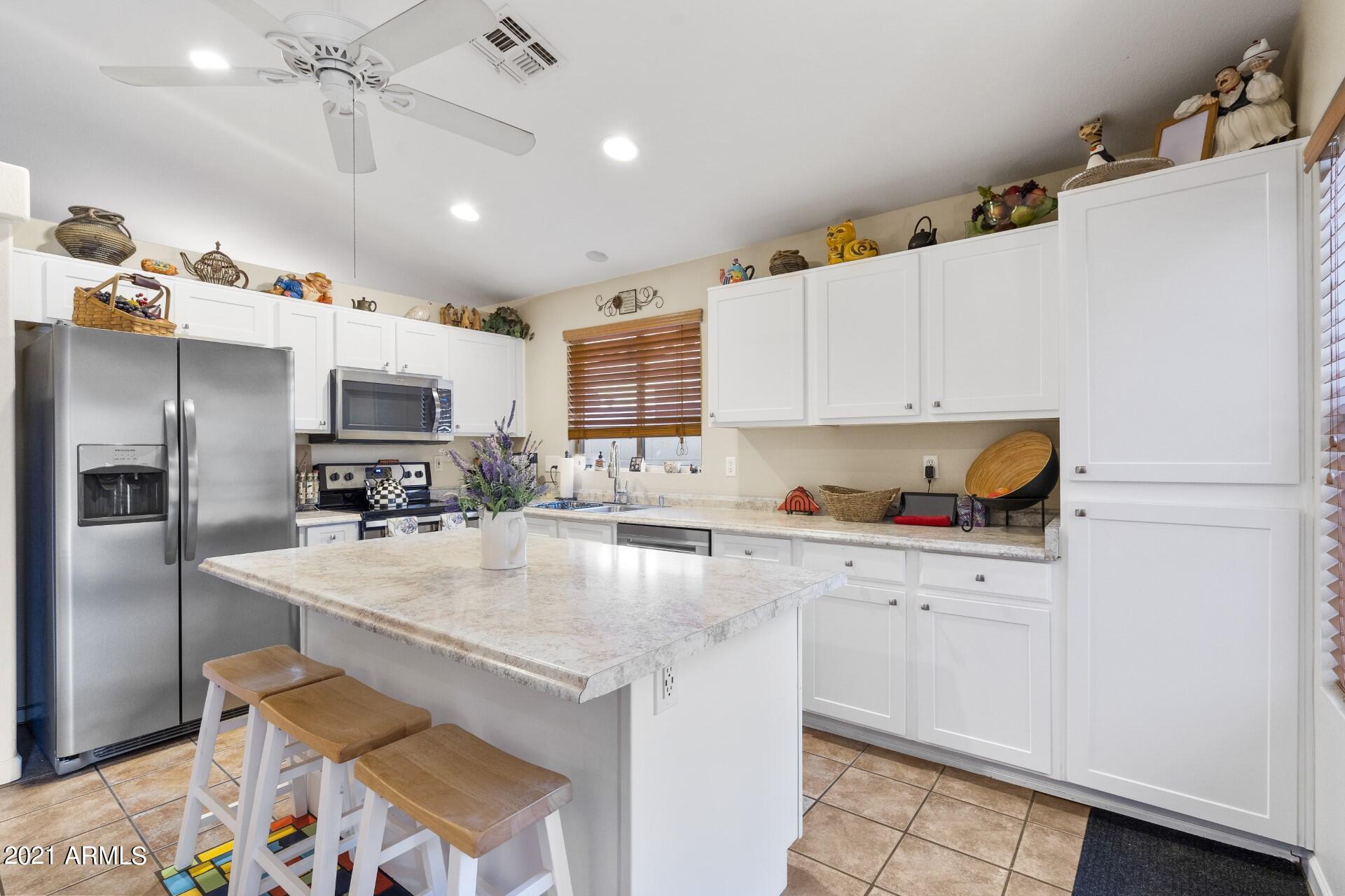 4161 West Bloomfield Road Phoenix, AZ 85029 - Photo 7 of 36 a kitchen with stainless steel appliances granite countertop a sink refrigerator and microwave