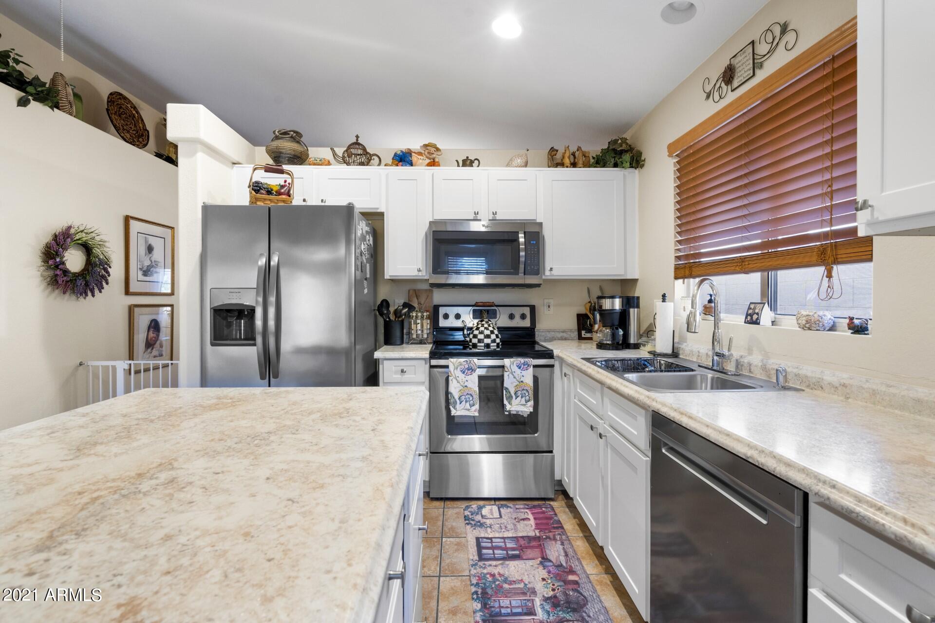 4161 West Bloomfield Road Phoenix, AZ 85029 - Photo 9 of 36 a kitchen with stainless steel appliances and a sink