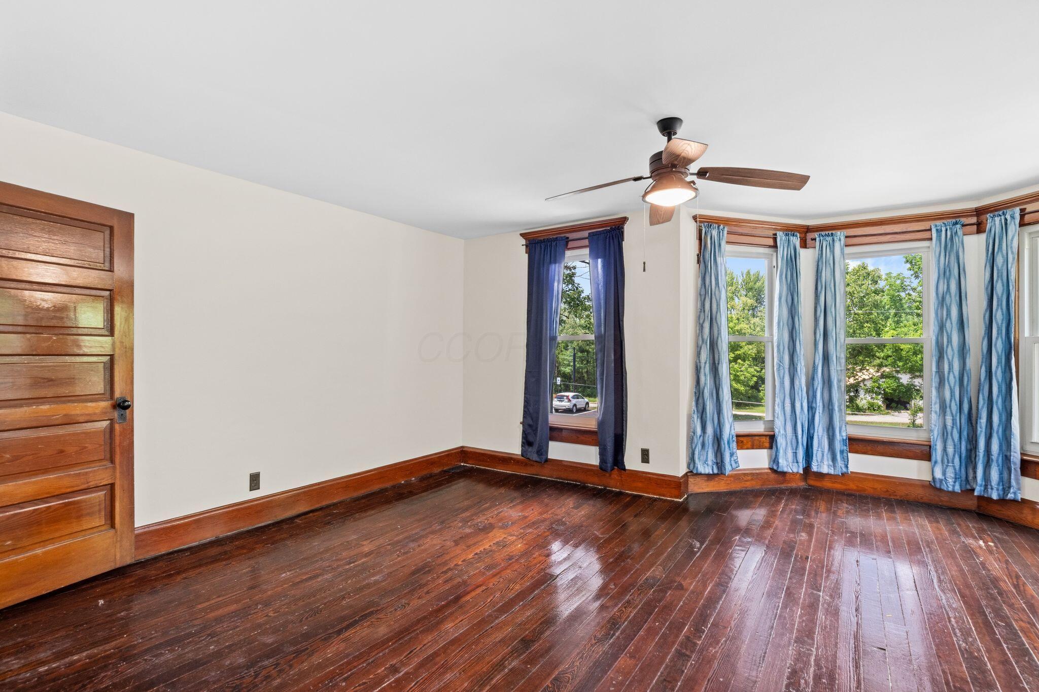 107 Price Road Columbus, OH 43230 - Photo 22 of 51 Hardwood flooring with a rich finish, a multi-paneled wood door, and a bay window featuring four individual panes