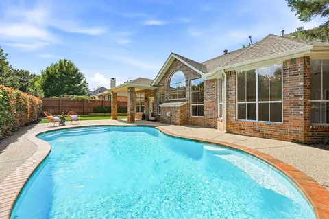 a view of a house with swimming pool and yard
