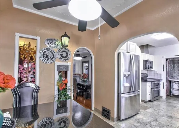 a kitchen with stainless steel appliances granite countertop a refrigerator a stove and a dining table