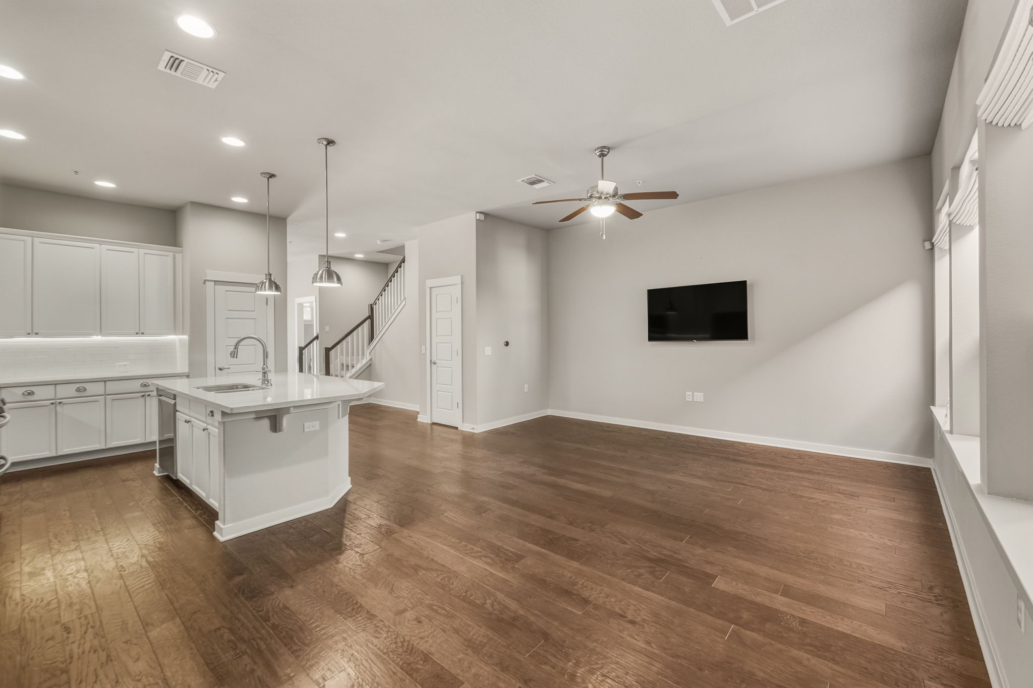 3919 Vaughan Street Austin, TX 78723 - Photo 39 of 40 Kitchen with white cabinets, hanging light fixtures, dark wood finished floors, open floor plan, and a center island with sink