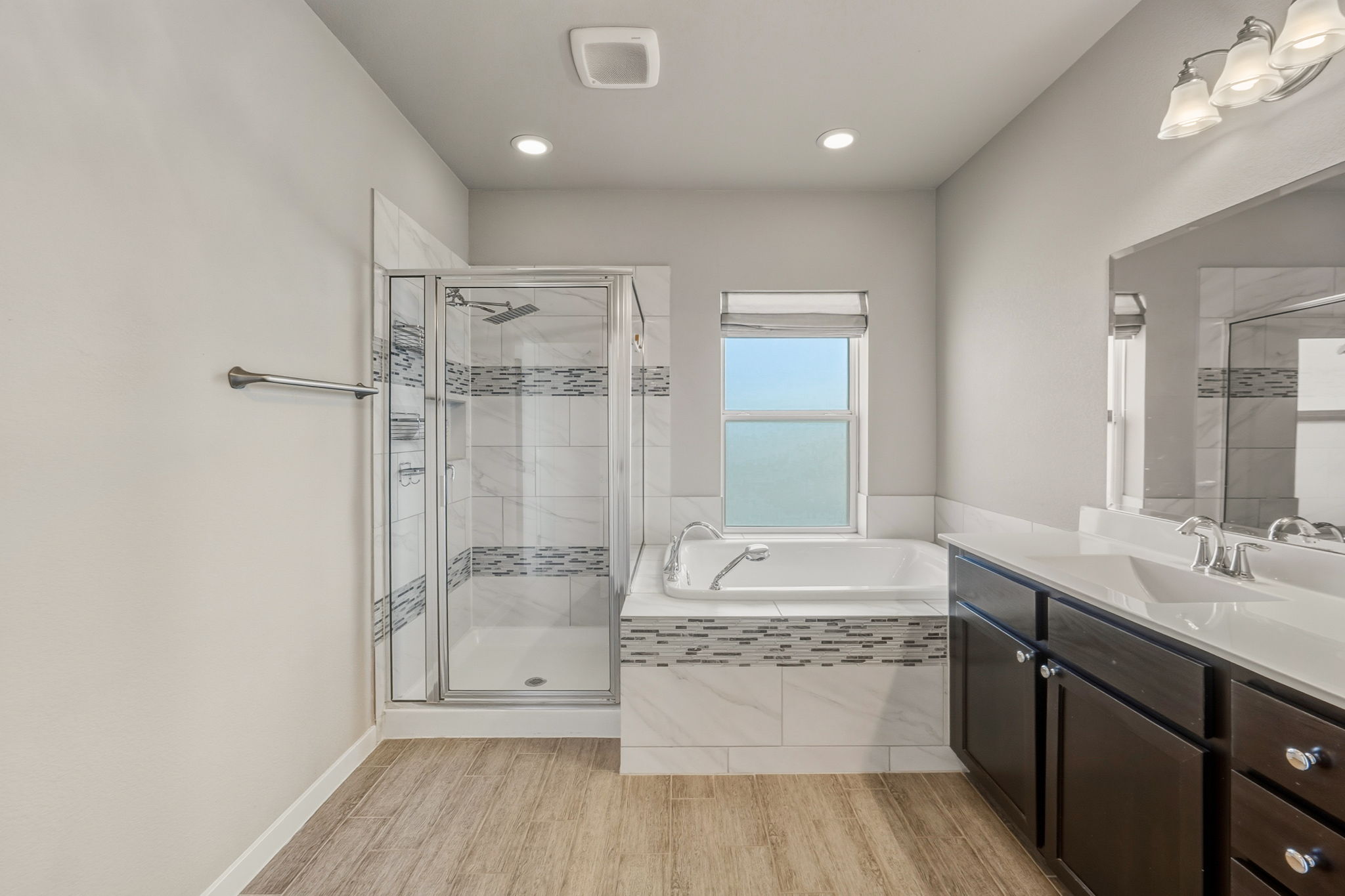 3919 Vaughan Street Austin, TX 78723 - Photo 23 of 40 Bathroom featuring a bath, vanity, a shower stall, and light wood-style floors