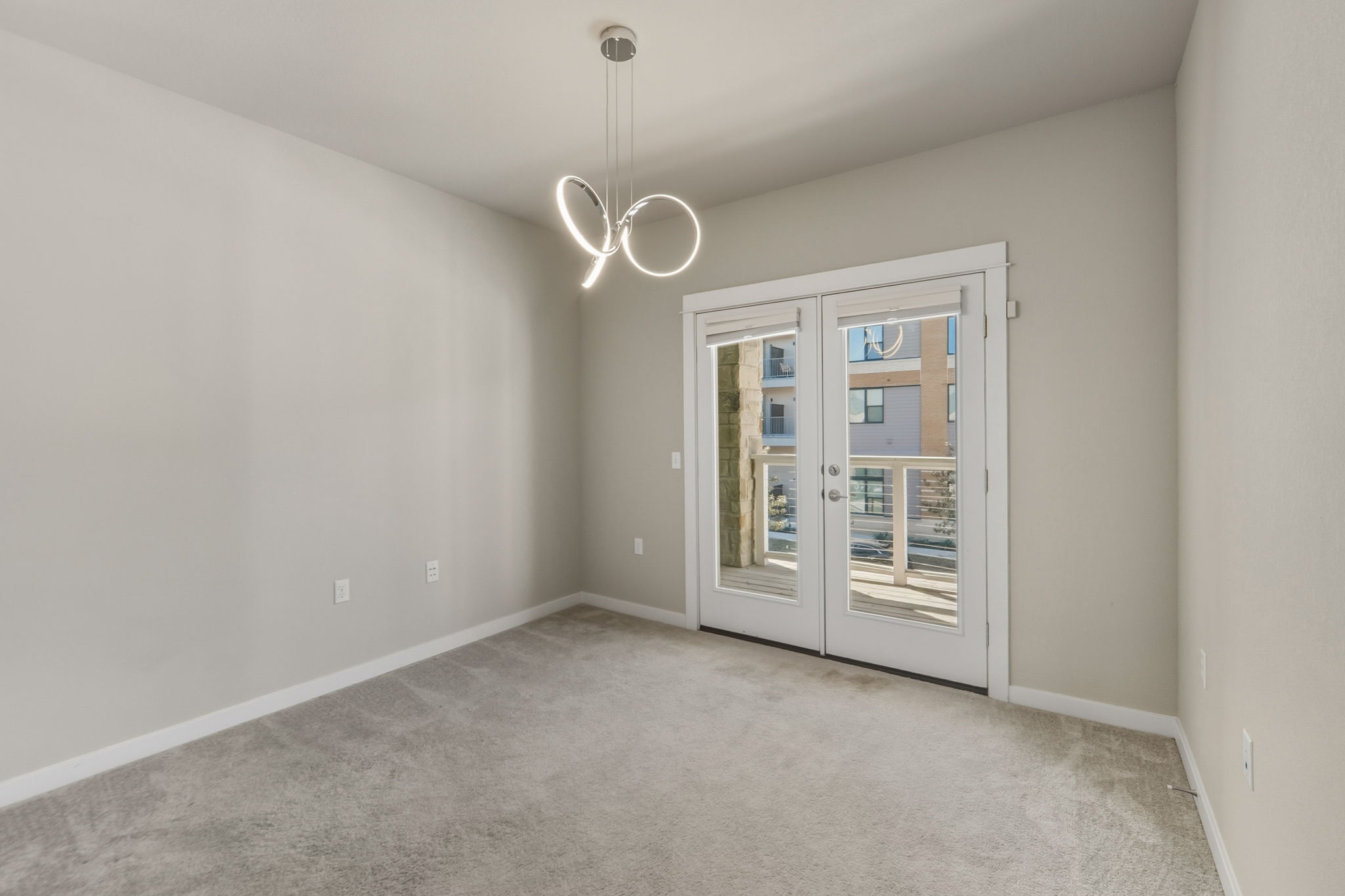 3919 Vaughan Street Austin, TX 78723 - Photo 25 of 40 Spare room featuring light colored carpet and hanging lights