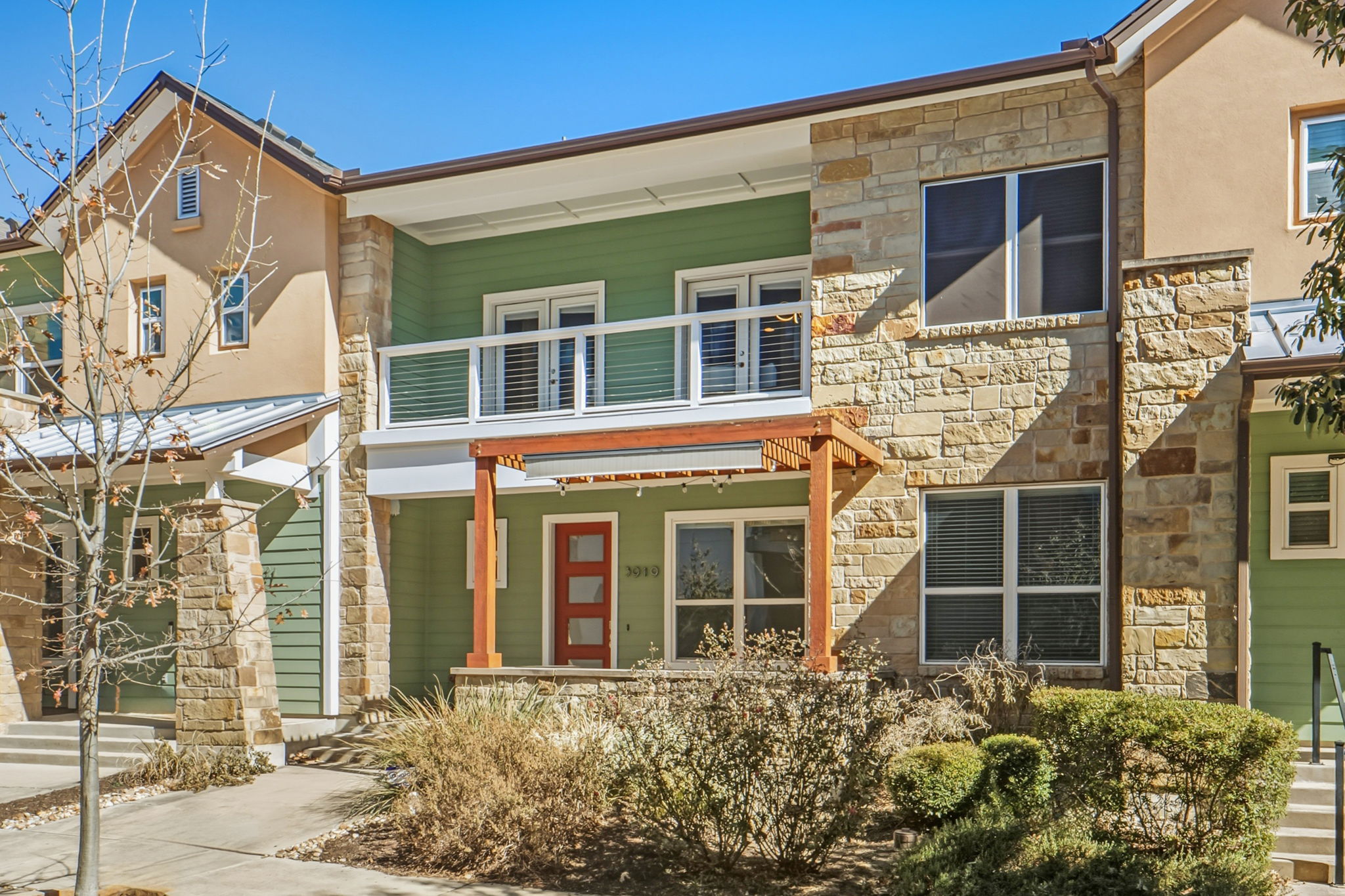 3919 Vaughan Street Austin, TX 78723 - Photo 3 of 40 View of front of home with stone siding, a balcony, and a porch