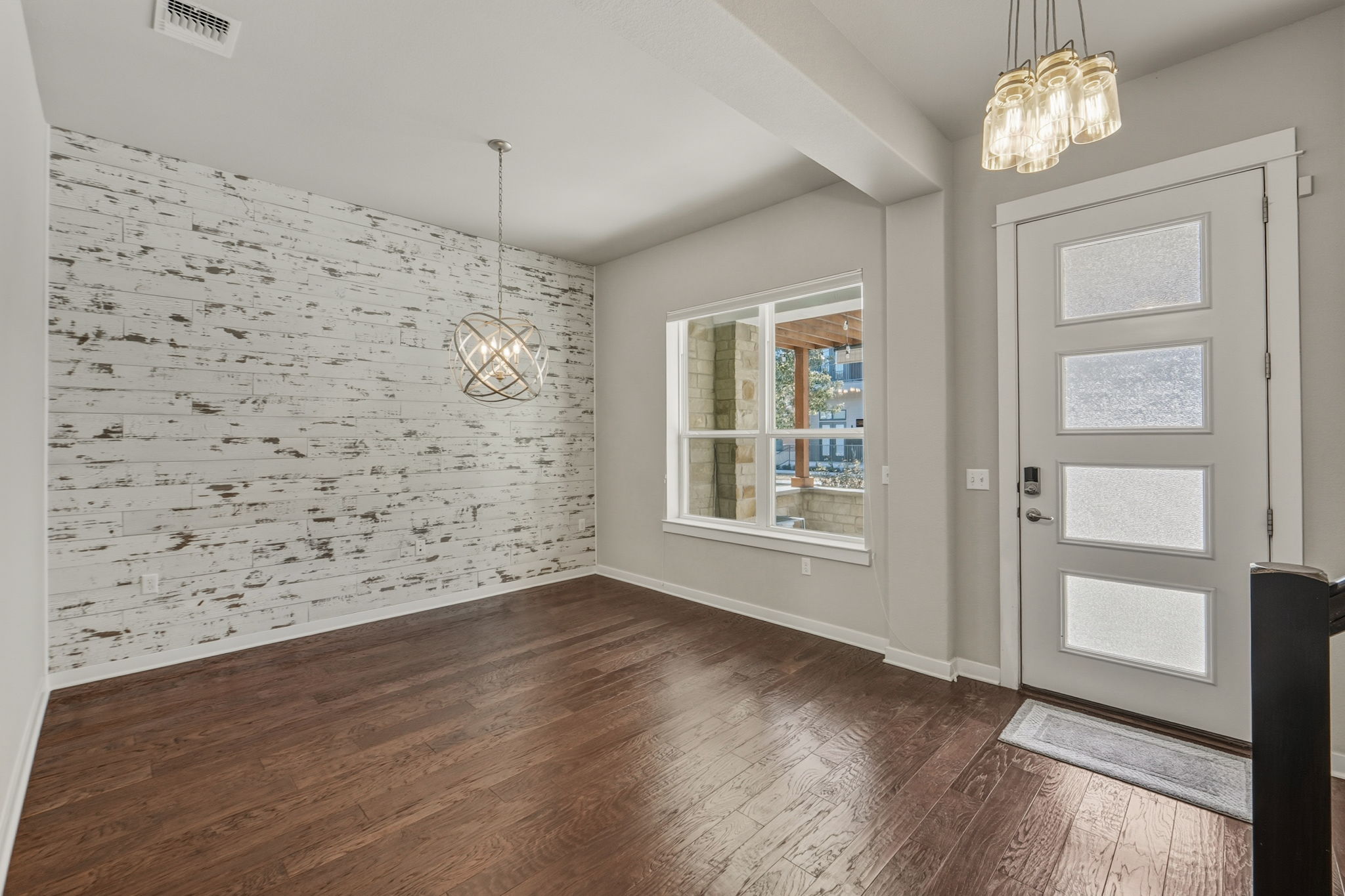 3919 Vaughan Street Austin, TX 78723 - Photo 9 of 40 Foyer with hanging lights, an accent wall, and dark wood-type flooring