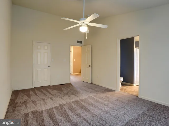 an empty room with a ceiling fan and a window