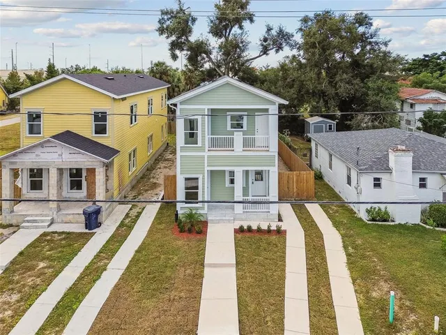 an aerial view of multiple houses with a yard