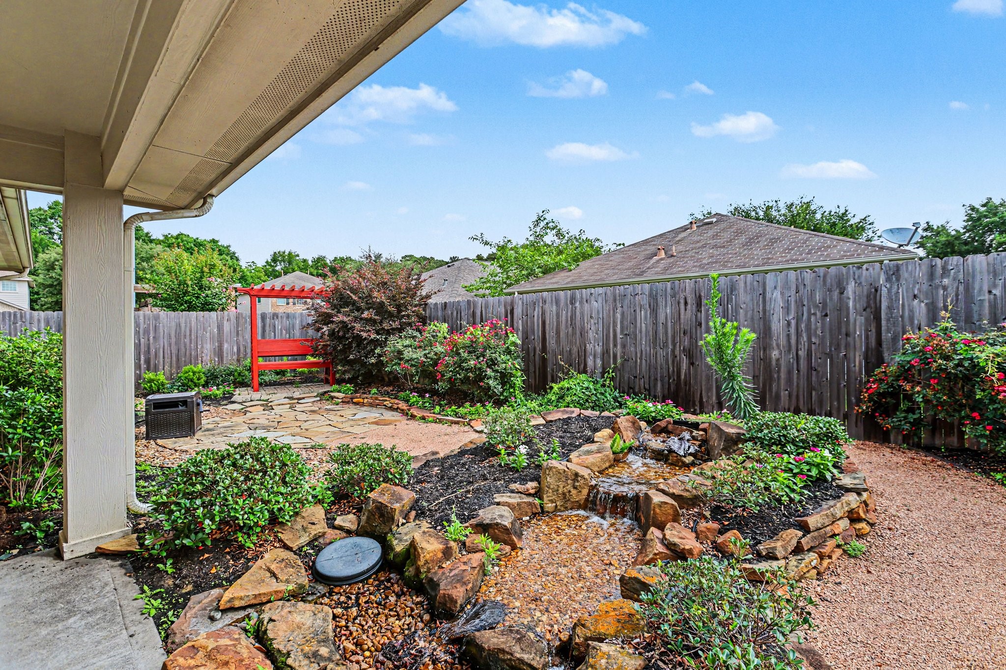 25222 Ginger Ranch Drive Katy, TX 77494 - Photo 31 of 33 Another view of the backyard garden with a vibrant red pergola with flowering plants, adding even more character.