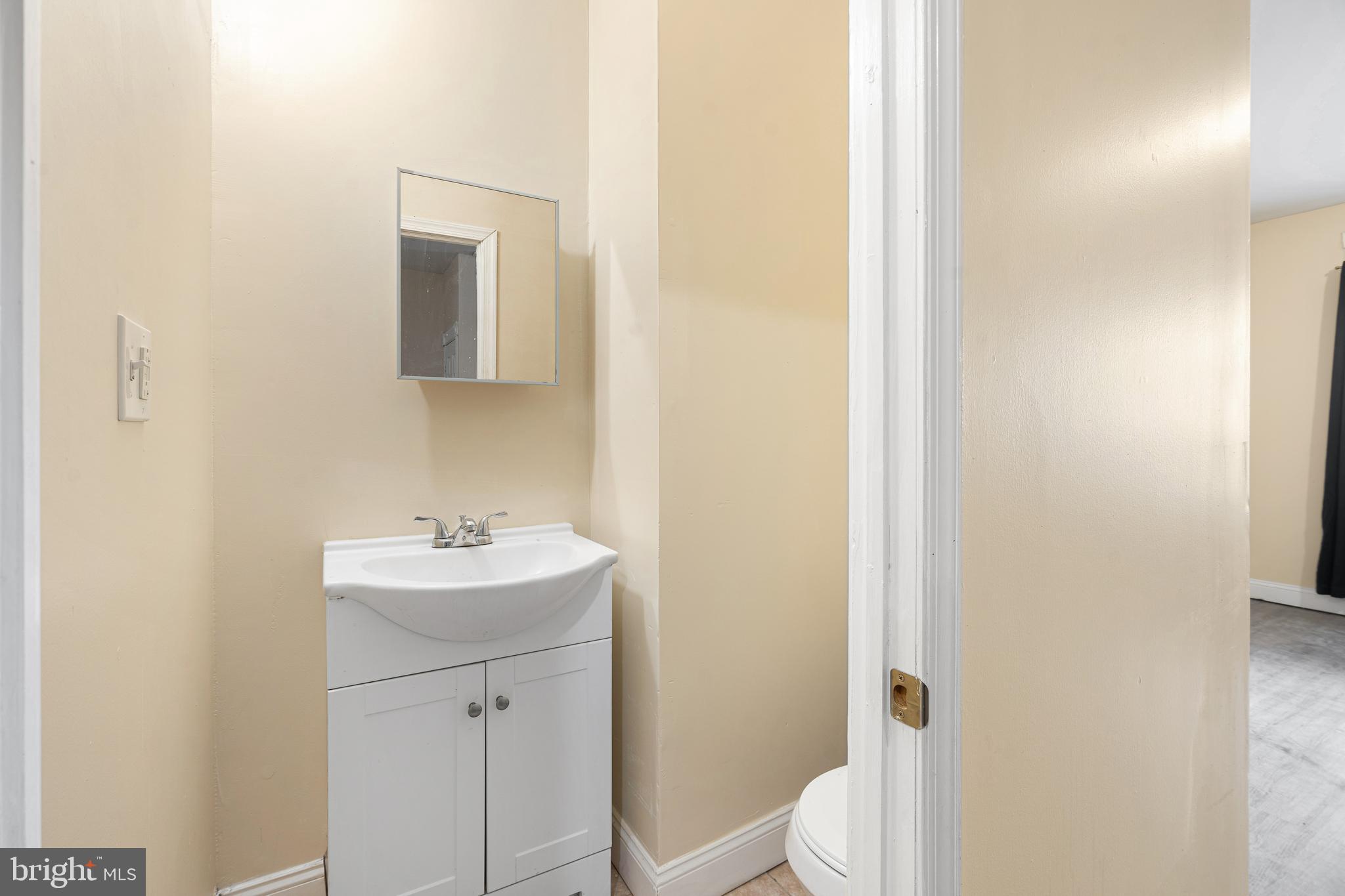 5538 Addison Street Philadelphia, PA 19143 - Photo 12 of 15 a bathroom with a toilet a sink and mirror