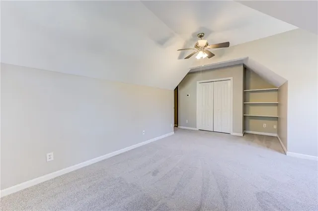 an empty room with closet and windows