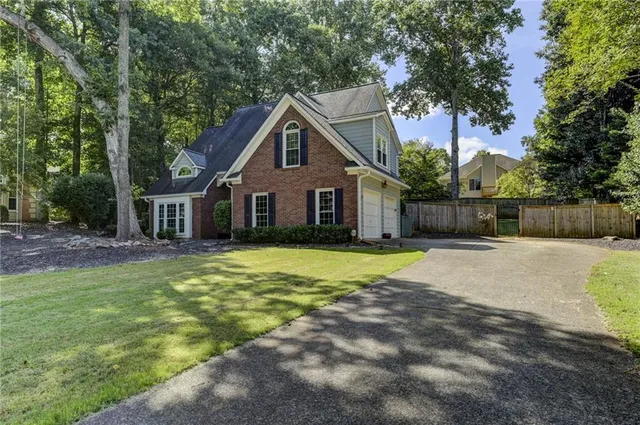 a view of a house with backyard and tree