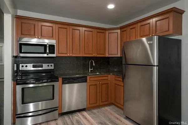 a kitchen with granite countertop stainless steel appliances and wooden cabinets