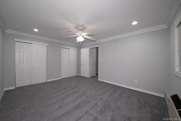an empty room with a ceiling fan and a window