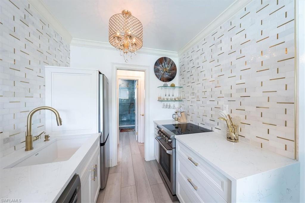 540 4th Avenue South, Unit 13 Naples, FL 34102 - Photo 11 of 19 a kitchen with a sink and a stove with a kitchen island
