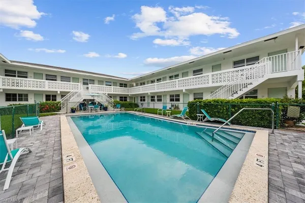 a view of house with swimming pool and outdoor seating