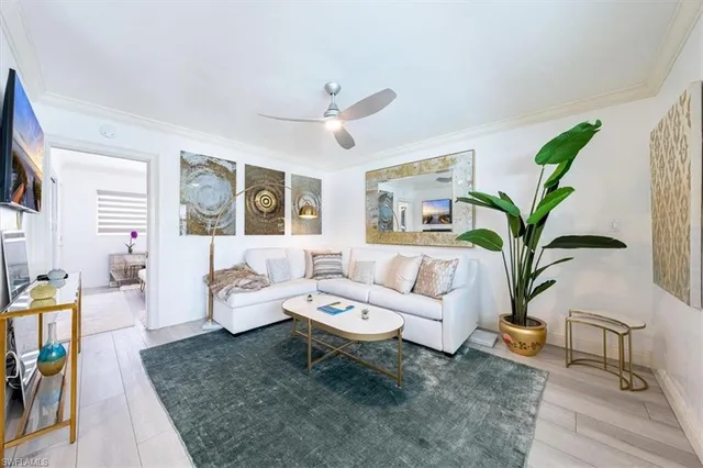 a living room with furniture a chandelier and a rug
