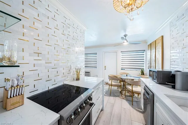 a kitchen with a stove a sink a dining table and chairs