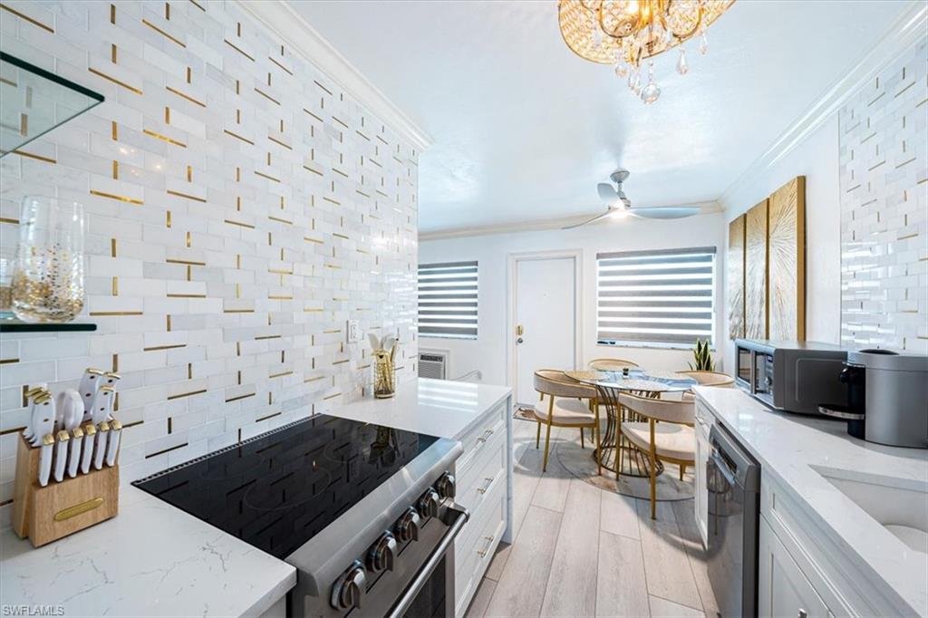 540 4th Avenue South, Unit 13 Naples, FL 34102 - Photo 8 of 19 a kitchen with a stove a sink a dining table and chairs