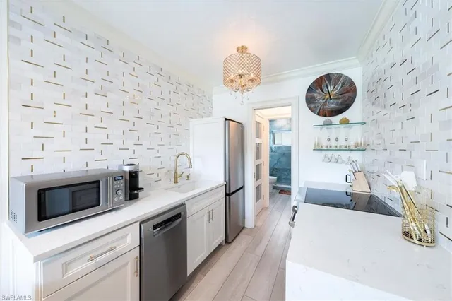 a kitchen with stainless steel appliances a stove a cabinets and a fireplace