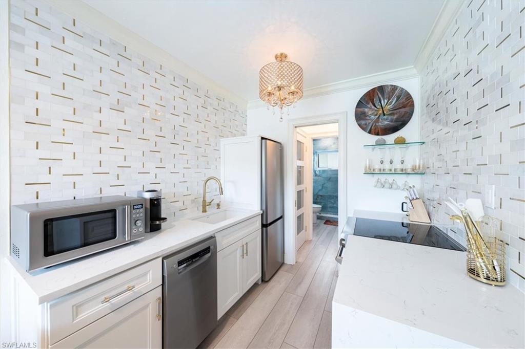 540 4th Avenue South, Unit 13 Naples, FL 34102 - Photo 9 of 19 a kitchen with stainless steel appliances a stove a cabinets and a fireplace