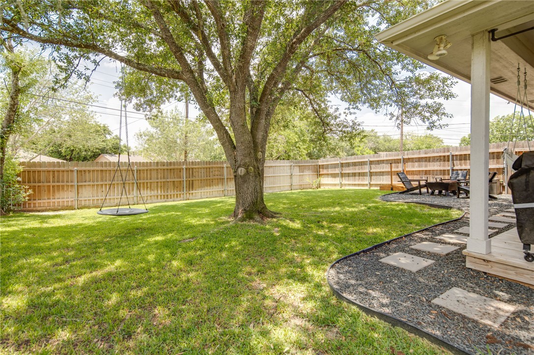 4700 Kensington Road Bryan, TX 77802 - Photo 27 of 31 Expansive green lawn featuring a mature tree, and privacy fencing