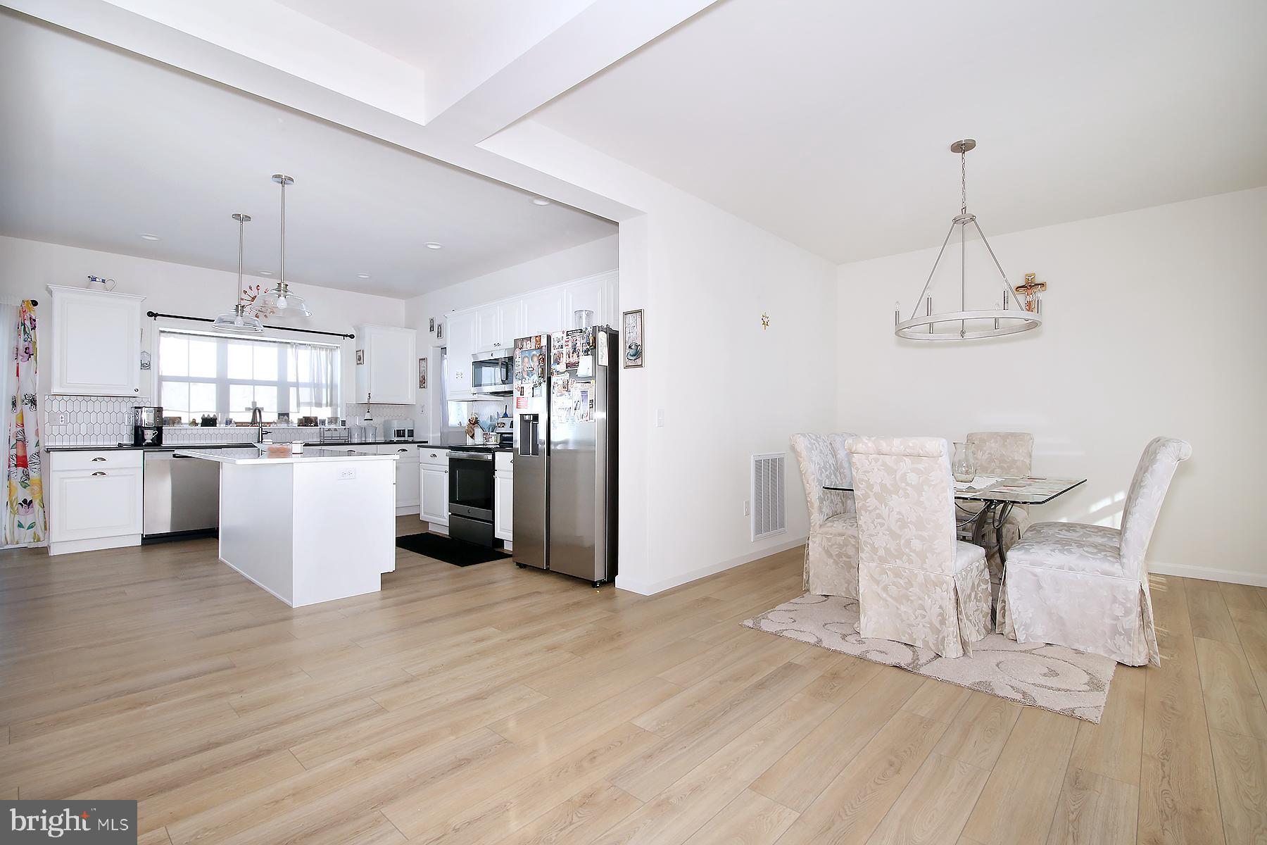 216 Copper Ridge Drive Newmanstown, PA 17073 - Photo 11 of 45 a kitchen with stainless steel appliances a dining table chairs refrigerator and cabinets