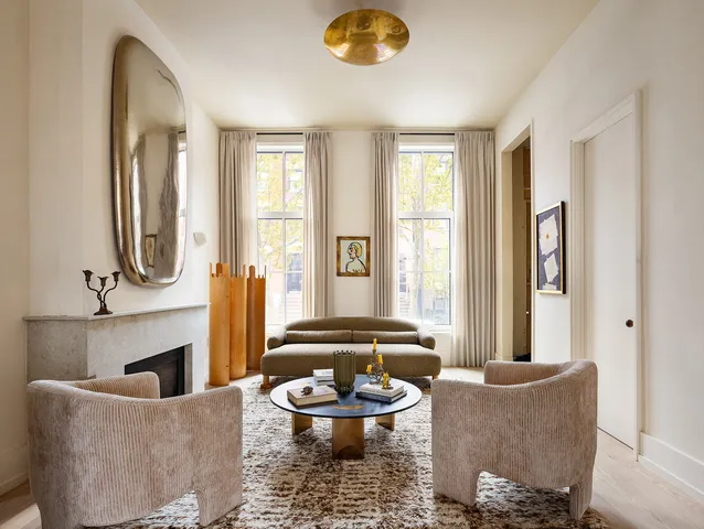 a living room with furniture a fireplace and a large window