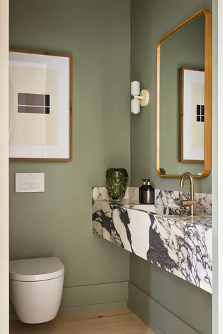a bathroom with a toilet sink and mirror