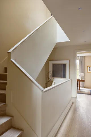 a stairs and an empty room with wooden floor
