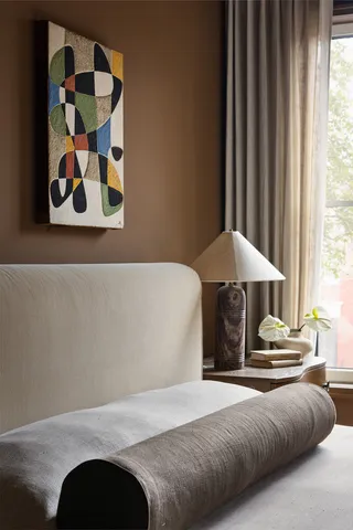 a bedroom with a bed and a painting on the wall