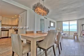 5555 Collins Avenue, Unit 5F Miami Beach, FL 33140 - Photo 3 of 6 a view of a dining room with furniture window and wooden floor